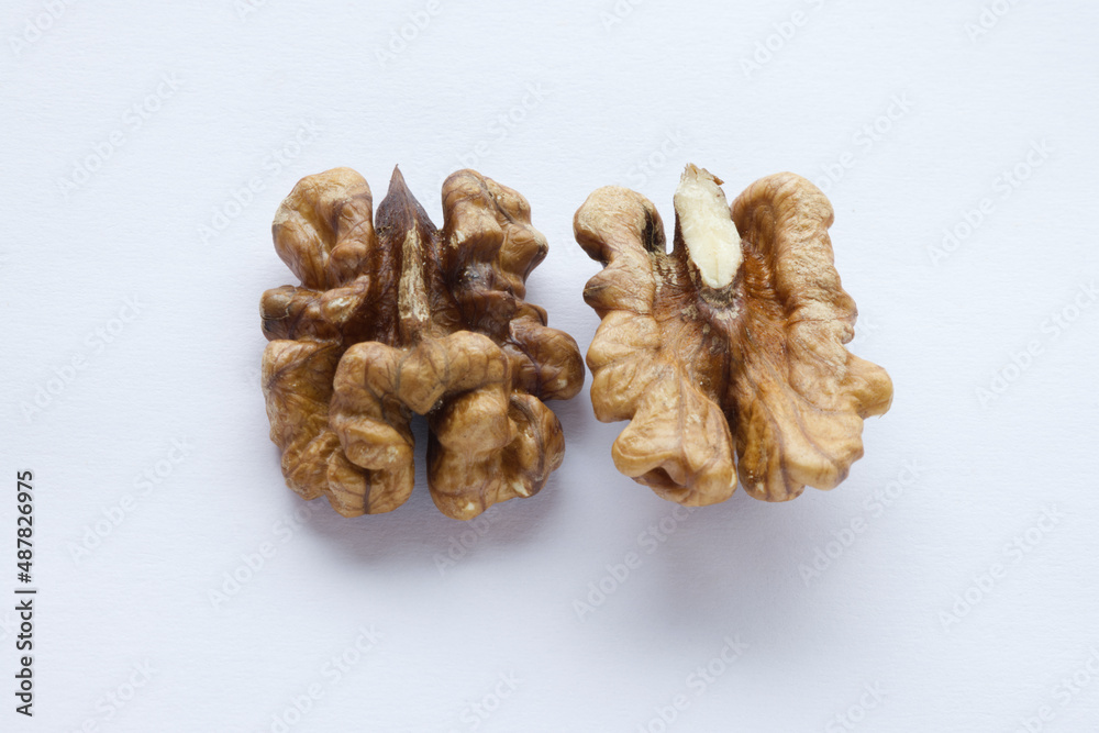 close up of half brown raw walnut cracked nuts, a splintered walnuts isolated on white background. set on upside down and front. top view close up of half brown raw walnut cracked nuts, a splintered walnuts isolated on white background. set on upside down and front. top view