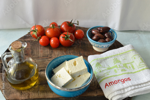 Greek feta cheese in the blue bowl and other fresh ingredients from Cyclades island, Amorgos, enjoying vacation in Greece