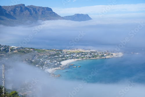 View from The Rock viewpoint in Cape Town over Campsbay, view over Camps Bay with fog over the ocean. fog coming in from ocean at Camps Bay Cape Town photo