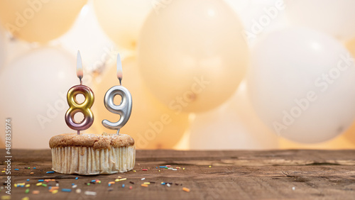 Happy birthday card with candle number 89 in a cupcake against the background of balloons. Copy space happy birthday for eighty nine years old photo