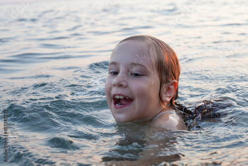 Portrait of cute happy child girl swimming and having fun on summer vacation © millaf