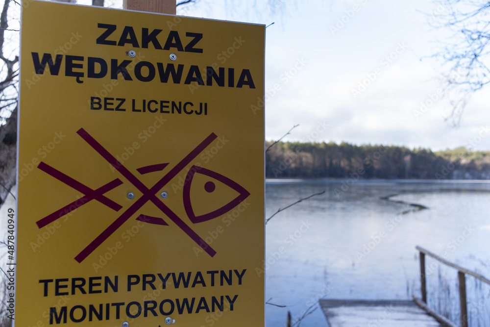 Tabliczka informacyjna o zakazie wędkowania na jeziorze bez wykupienia odpowiedniej licencji - obrazy, fototapety, plakaty 