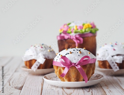 Easter pastries decorated with pastry sprinkles and ribbons on a white wooden background.We are preparing for the Easter holiday and baking cakes.