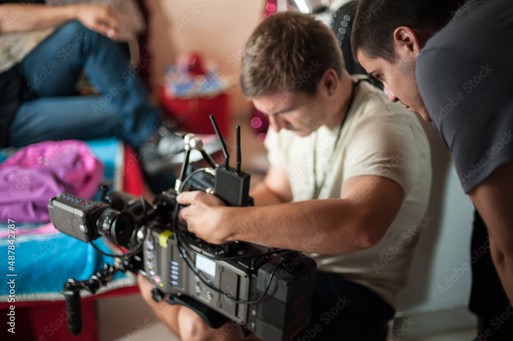 Behind the scene. Cameraman with his camera on outdoor set Behind the scene. Cameraman with his camera on outdoor set