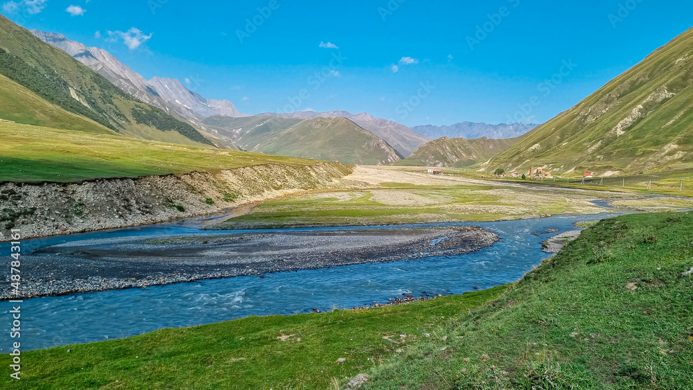 The Terek (Tergi) river flows down the Truso Valley near the Ketrisi Village Kazbegi District,Mtskheta in the Greater Caucasus Mountains,Georgia.Ketrisi village and Zakagori Fortress in the distance