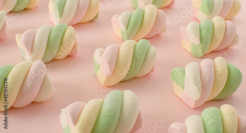 Colorful marshmallows composition on a pink background - copy space