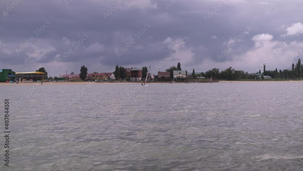 view of the beach from the sea.an athlete goes windsurfing.entertainment at the sea. sport view of the beach from the sea.an athlete goes windsurfing.entertainment at the sea. sport