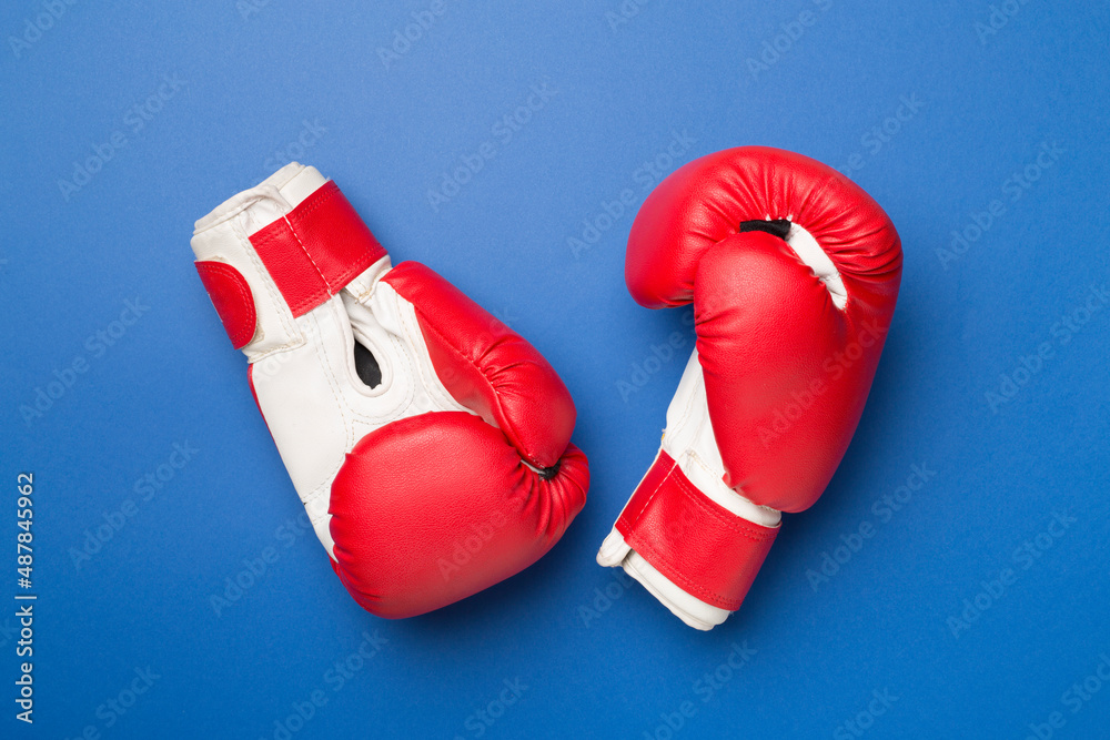 Pair of red boxing gloves on color background. Top view