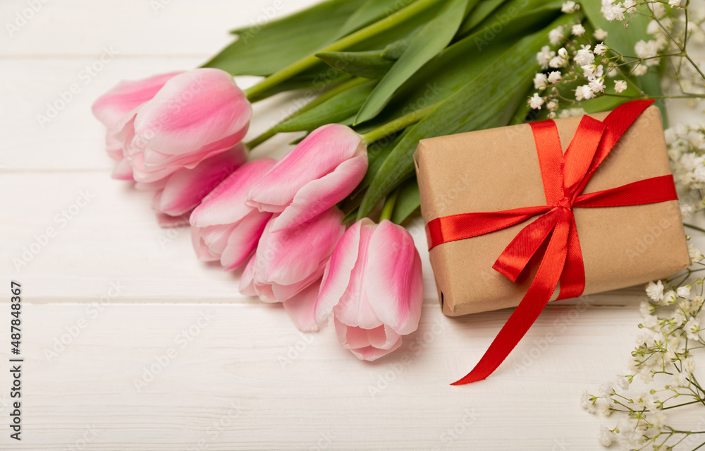 Pink tulips and gypsophila gift box on a white wooden background.Side view. Spring bouquet.Holiday concept.Women's day, Valentine's day,Easter, birthday.Copy space. Pink tulips and gypsophila gift box on a white wooden background.Side view. Spring bouquet.Holiday concept.Women's day, Valentine's day,Easter, birthday.Copy space.