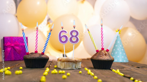 A beautiful birthday card for a woman with the number 68 in a cupcake against the background of balloons. Congratulations on the birthday of sixty-eight years for a woman photo