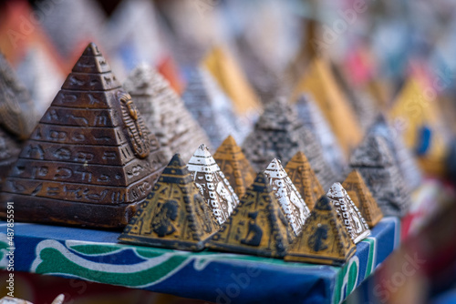 Many small colorful pyramid souvenirs for sale on the streets of cairo, egypt. Salesman looking to earn money and haggle with tourists, stone, limestone and alabaster figurines for sale