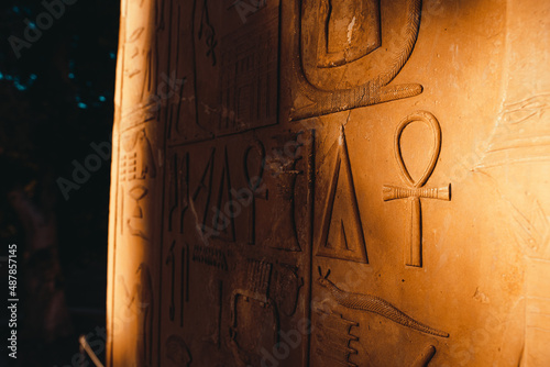 Close up of ancient egyptian hieroglyph symbols as seen on a yellow sandy wall in egyptian ruins. Remains of the great egyptian civilization photo