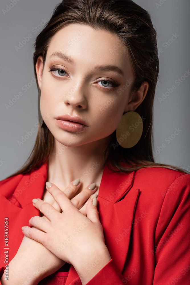 pretty model in red blazer looking at camera isolated on grey. pretty model in red blazer looking at camera isolated on grey.