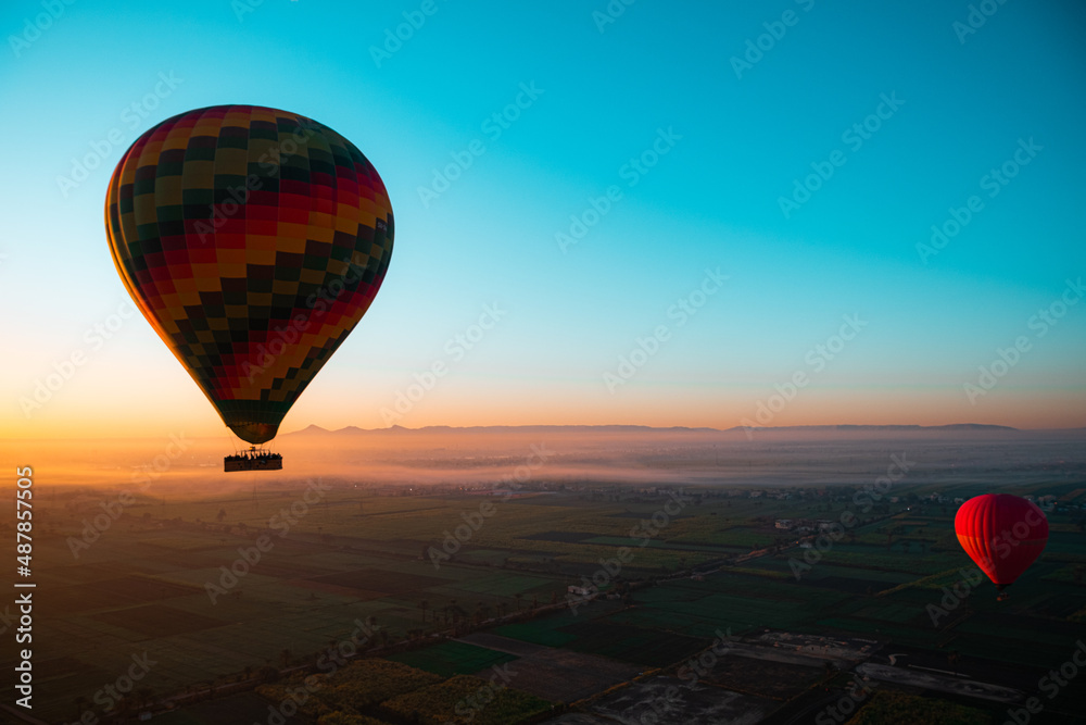 Amazing view of a bright colorful balloon, early morning sunrise in luxor area in egypt. Surrounding area illuminated providing an amazing view.