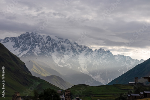 Amazing view on the Lamaria church in the mountain village Ushguli  near the snowy Shkhara peak in the Greater Caucasus Mountain Range in Georgia  Svaneti Region. View on the Shkhara Glacier. Sunset