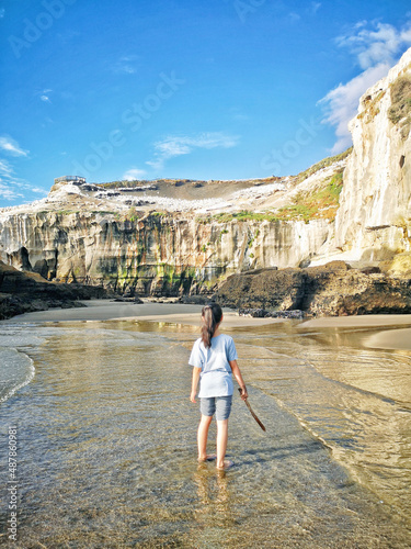 A beautiful shot of a person near a seascape taken in Maukatia Bay, Muriwai, Auckland photo