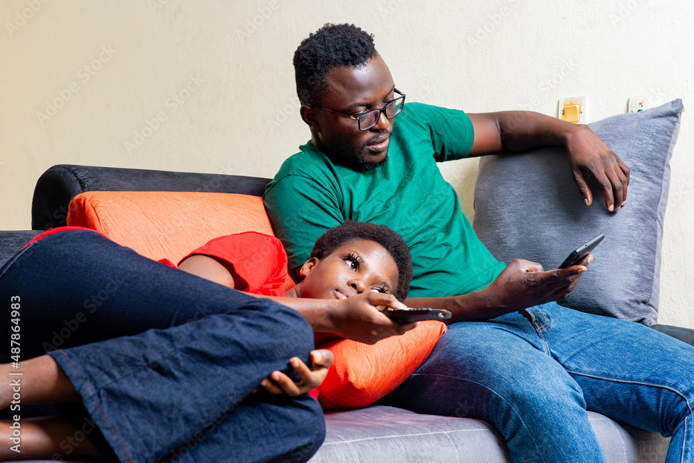 beautiful young couple sitting together on a sofa at home. beautiful young couple sitting together on a sofa at home.