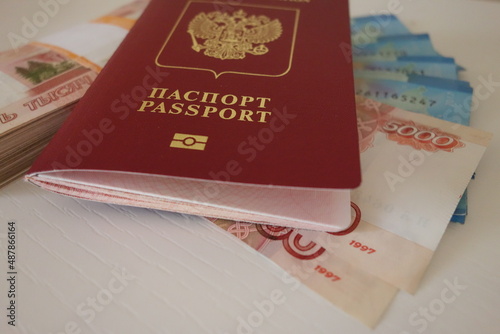 business, finance, saving, banking, travel and people concept - close up bundle of money Russian Banknotes thousand rubles with red passport. High quality photo