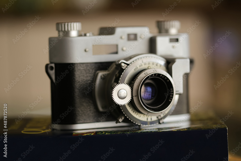 Vintage old photography film camera with lens on a book. Close up shot