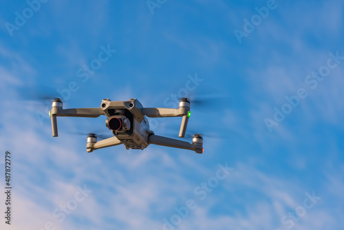 An unmanned quadcopter with a digital camera in the blue sky. © Danil Evskiy