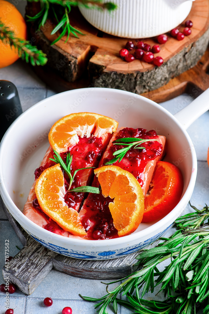 Baked salmon with tangerines in cranberry sauce in a white pan.style vintage Baked salmon with tangerines in cranberry sauce in a white pan.style vintage