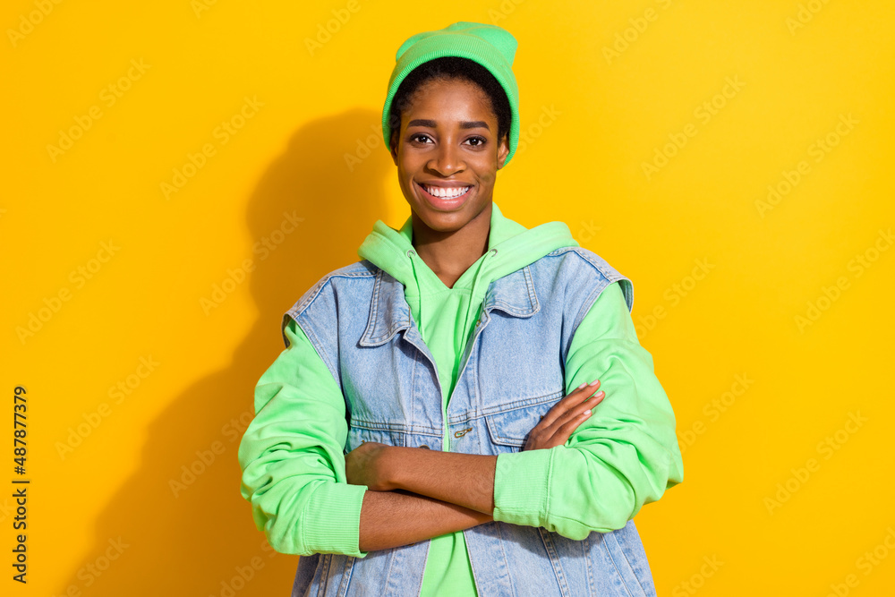 Portrait of attractive cheerful content girl wearing hoodie folded arms isolated over bright yellow color background Portrait of attractive cheerful content girl wearing hoodie folded arms isolated over bright yellow color background