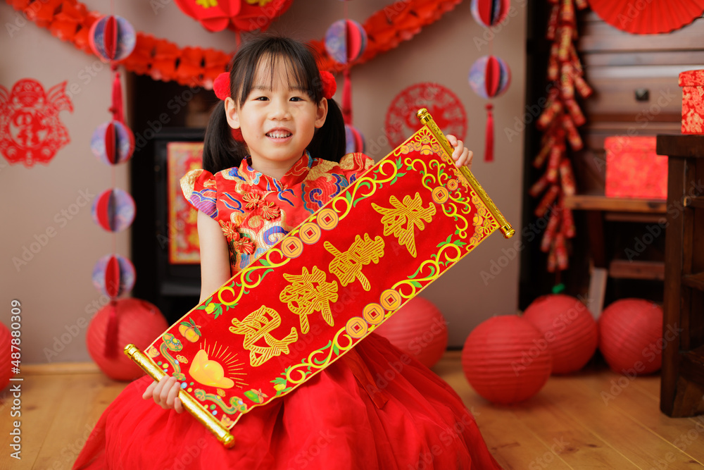 young Chinese girl with traditional dressing up holding "kung hei fat
