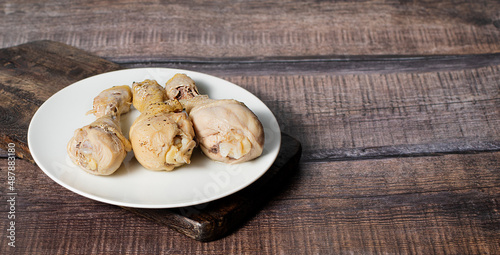 Steamed or boiled chicken thigh on dark wooden background, stock photo, selective focus