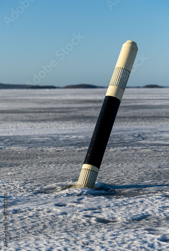Fototapeta Naklejka Na Ścianę i Meble -  Navigation mark - beacon at frozen lake. Sunny day.