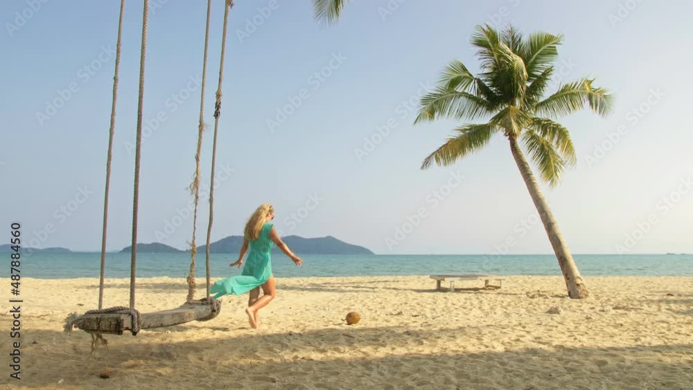 Woman spends her vacation at the seaside. The girl is swinging on a swing. Concept meditation, relaxation and walks, replenishment of energy and good happy mood. Woman spends her vacation at the seaside. The girl is swinging on a swing. Concept meditation, relaxation and walks, replenishment of energy and good happy mood.