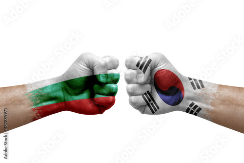 Two hands punch to each others on white background. Country flags painted fists, conflict crisis concept between bulgaria and south korea