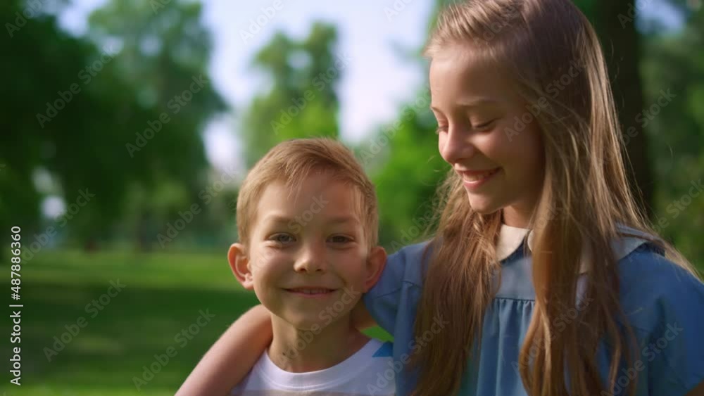 Lovely smiling siblings hugging in park. Preteen kids posing in park close up. Lovely smiling siblings hugging in park. Preteen kids posing in park close up.