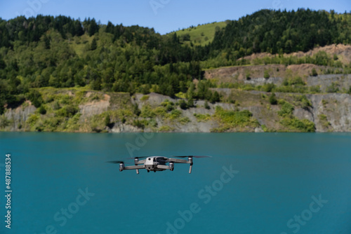 Fototapeta Naklejka Na Ścianę i Meble -  Aerial photography from a bird's eye view, a helicopter flies in the forest, photographs the nature of the lake. In the summer afternoon in the forest, a professional drone with a 4K camera shoots 