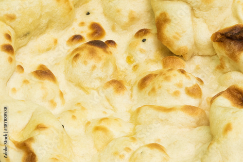 Naan is a flat bread, made from wheat flour and usually leavened. It is commonly consumed in various regions of Central Asia and South Asia. photo