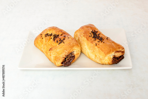 It is a cream filling wrapped in a puff pastry, which gives it its rectangular and flattened shape. The Neapolitan is sometimes covered with toasted almonds on top.