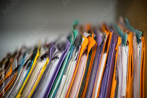 Paper files in folders, old documents for storage and archiving by stacking on shelf. Concept for working from home, office work, organising , research and  collecting.  photo
