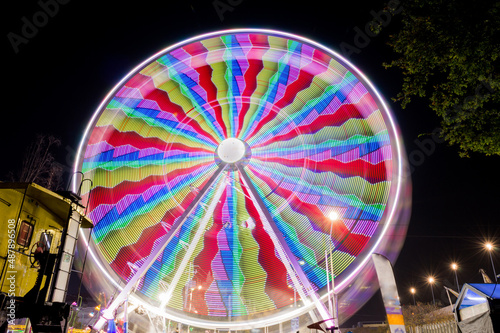 Rueda de la fortuna en parque de diversiones por la noche