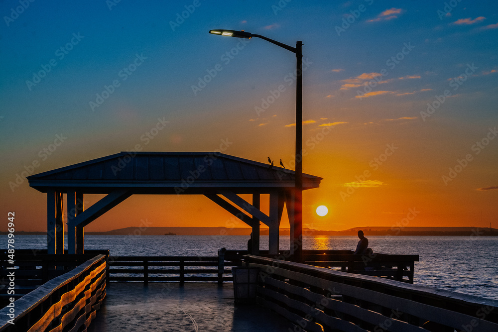 Person on Ballast Point pier at sunrise