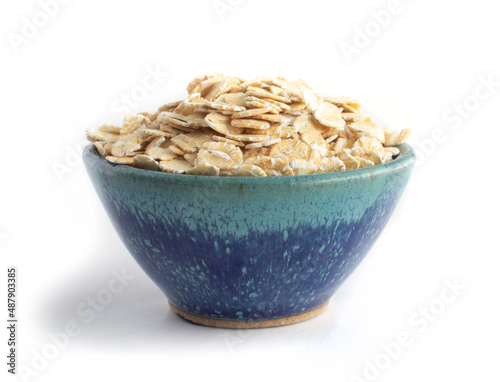Barley Flakes in Blue Pottery Bowl Isolated on White