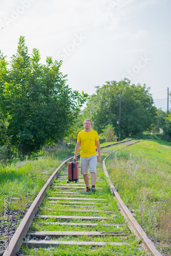 happy man with suitcase walking on the railroad © Vyacheslav