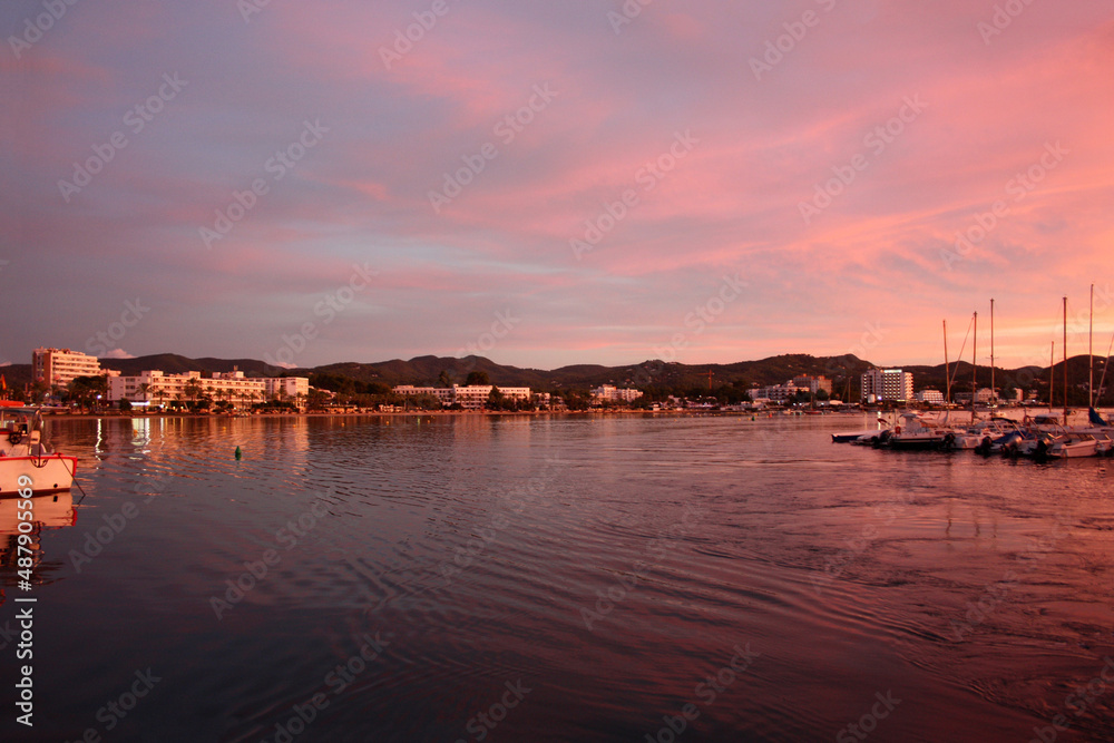 romantic pink sunset over the sea waters of the port of san antonio in ibiza