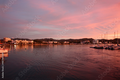 romantic pink sunset over the sea waters of the port of san antonio in ibiza