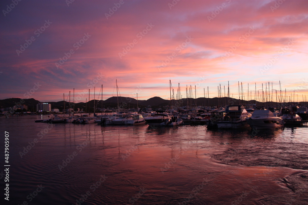 Fototapeta premium romantic pink sunset over the sea waters of the port of san antonio in ibiza