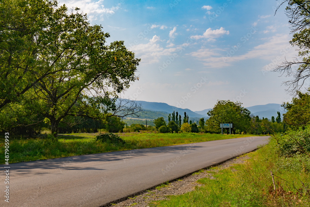 Fototapeta premium wide paved road towards the mountains goes