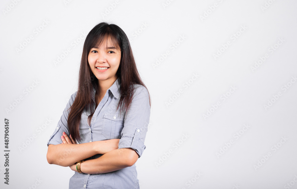 Woman standing her smile confidence with crossed arms isolated white background, Asian happy portrait beautiful young Thai female looking to camera in studio shot on white background and copy space Woman standing her smile confidence with crossed arms isolated white background, Asian happy portrait beautiful young Thai female looking to camera in studio shot on white background and copy space