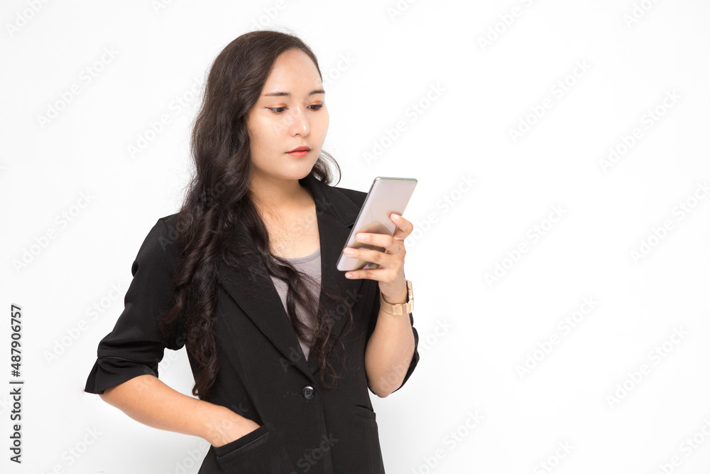Beautiful Asian business woman wearing black suit holding smartphone on white background and copy space. Confident Asian working woman smiling and cheerful Beautiful Asian business woman wearing black suit holding smartphone on white background and copy space. Confident Asian working woman smiling and cheerful