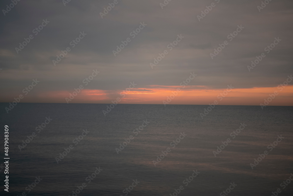 Evening orange sunset over a calm sea in summer.