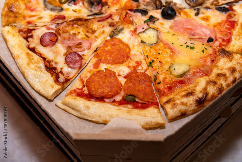 Pizza cut into pieces in a shipping carton.