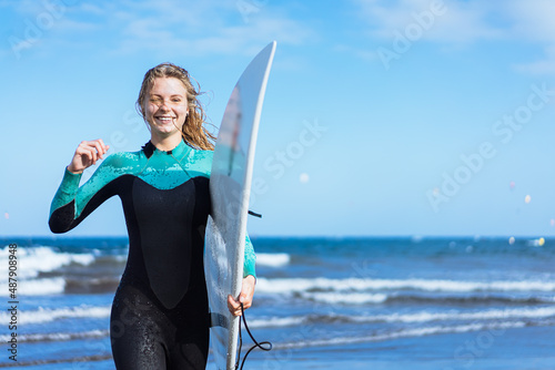 Photography Surfer girl walking with board on the sandy beach