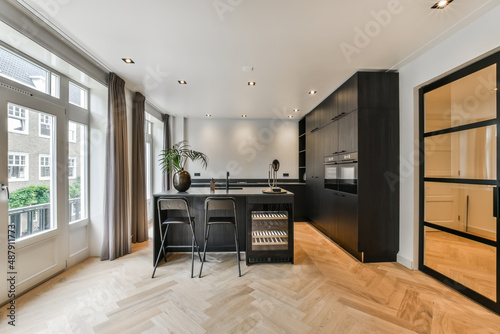 Modern kitchen with black furniture and wooden floor photo